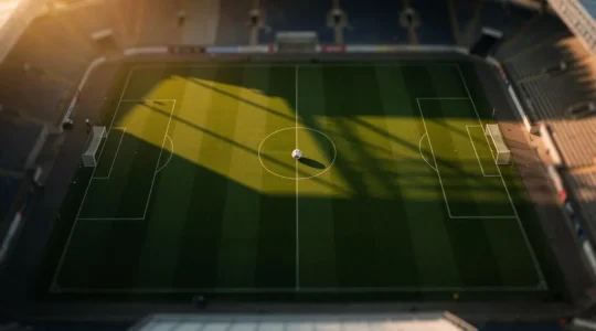 Terrain de football vu de haut au crépuscule, symbolisant l'équilibre et la justice sportive entre deux camps